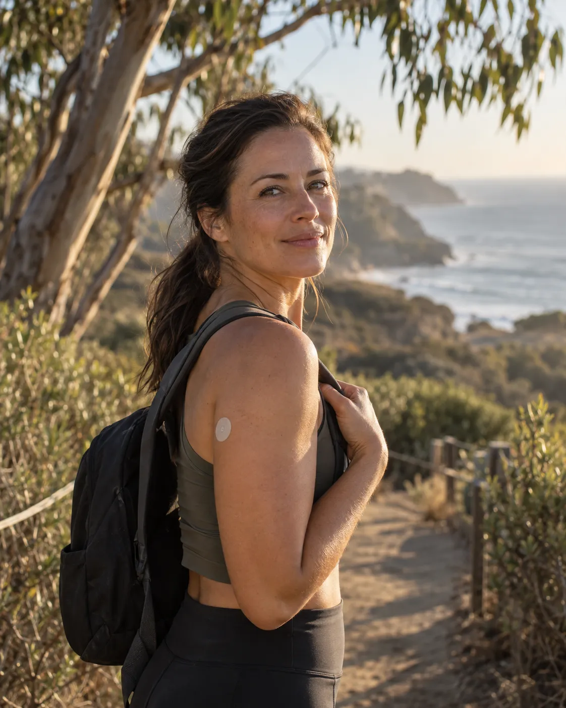 Woman wearing a wellness patch on a coastal walking trail